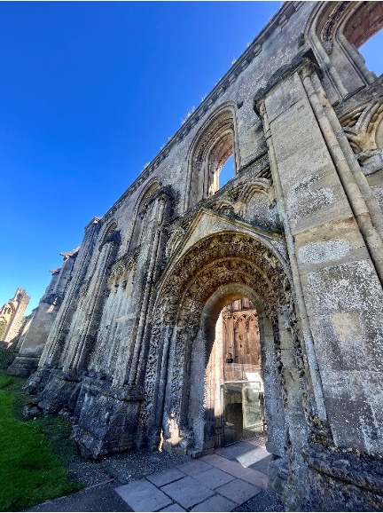 Ruins of the Glastonbury Abbey tower over the image.